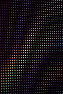 A close up view of a black background with multicolored dots