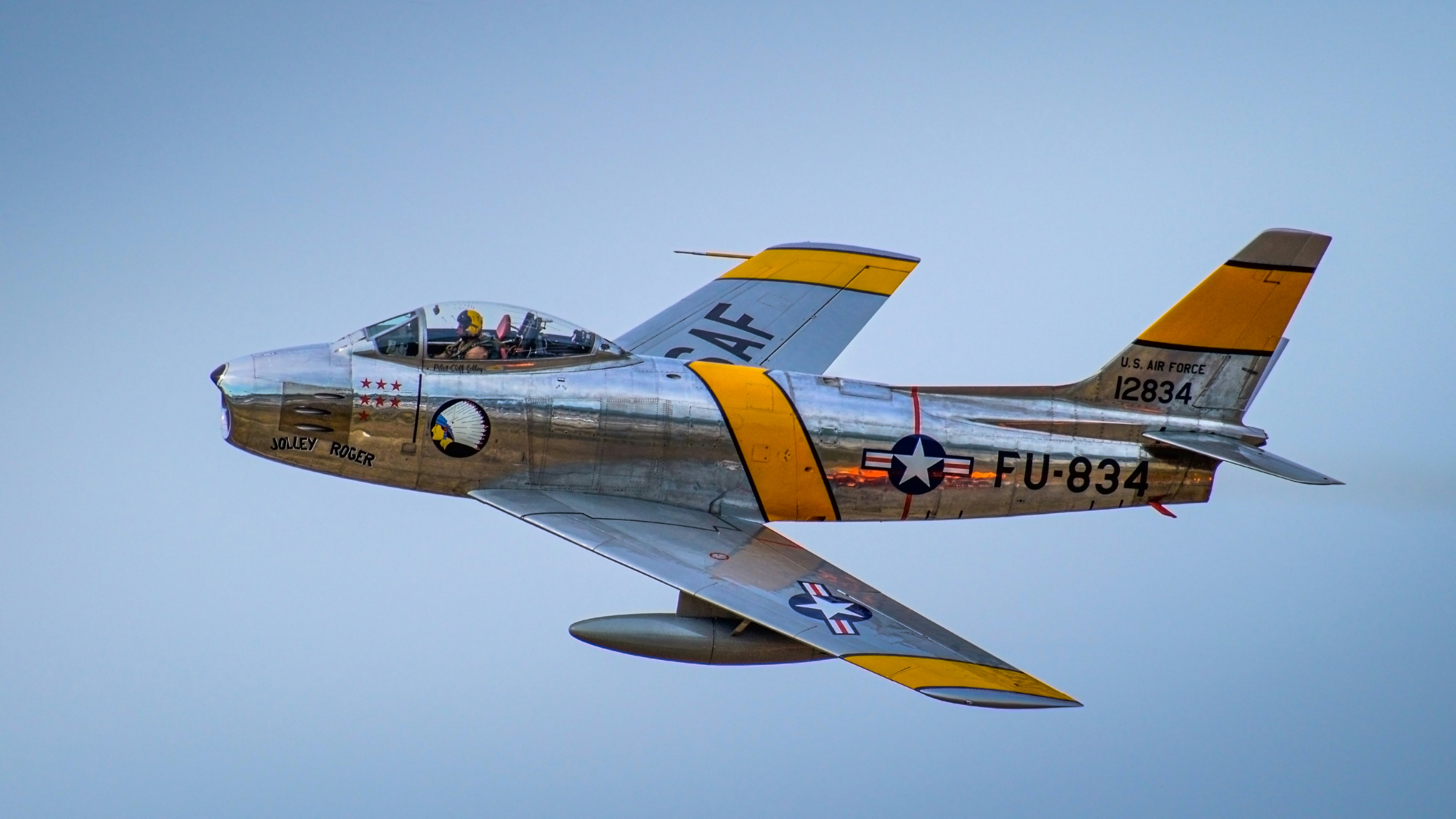 A fighter jet flying through a blue sky