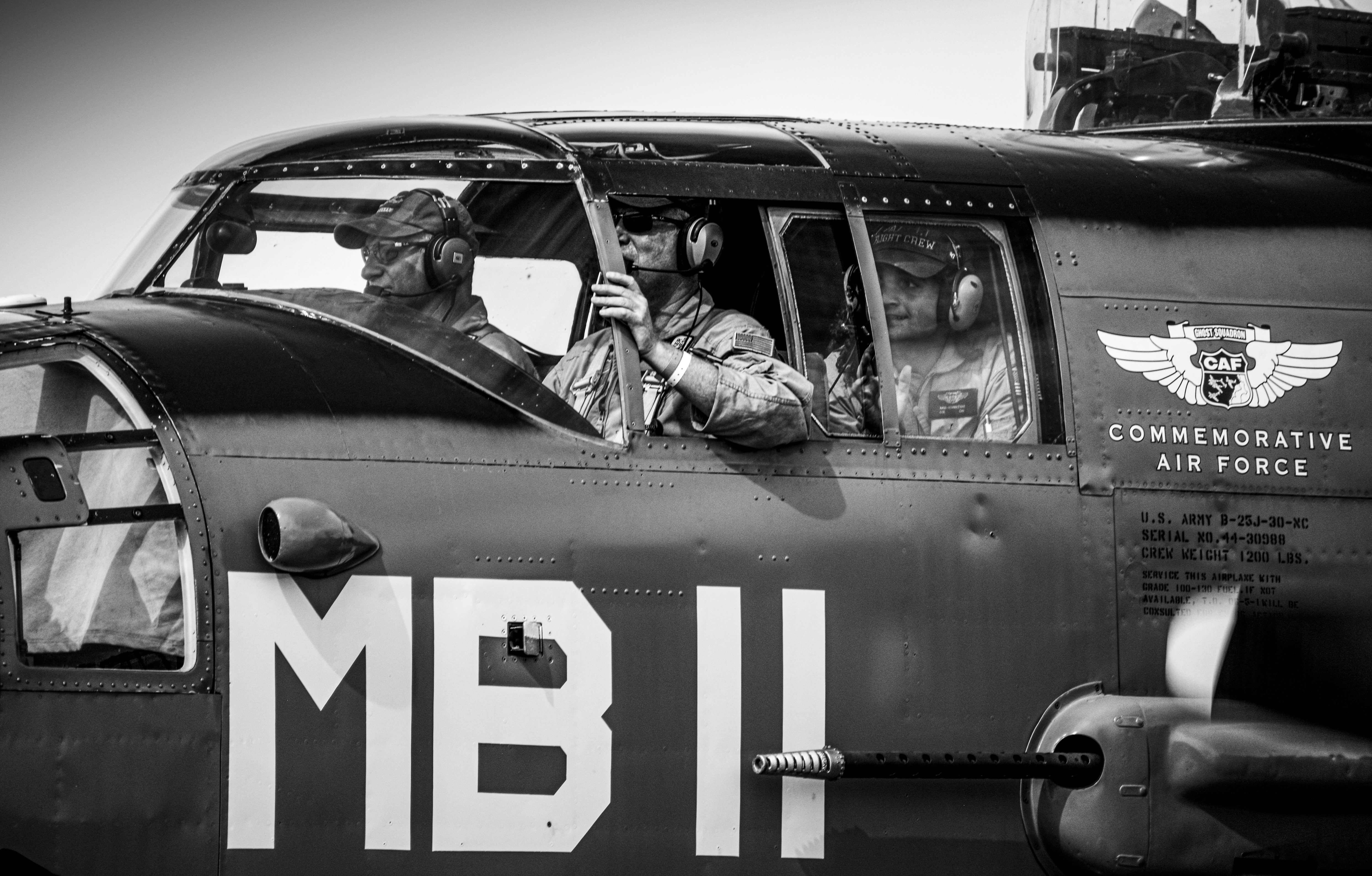 A black and white photo of men in an airplane