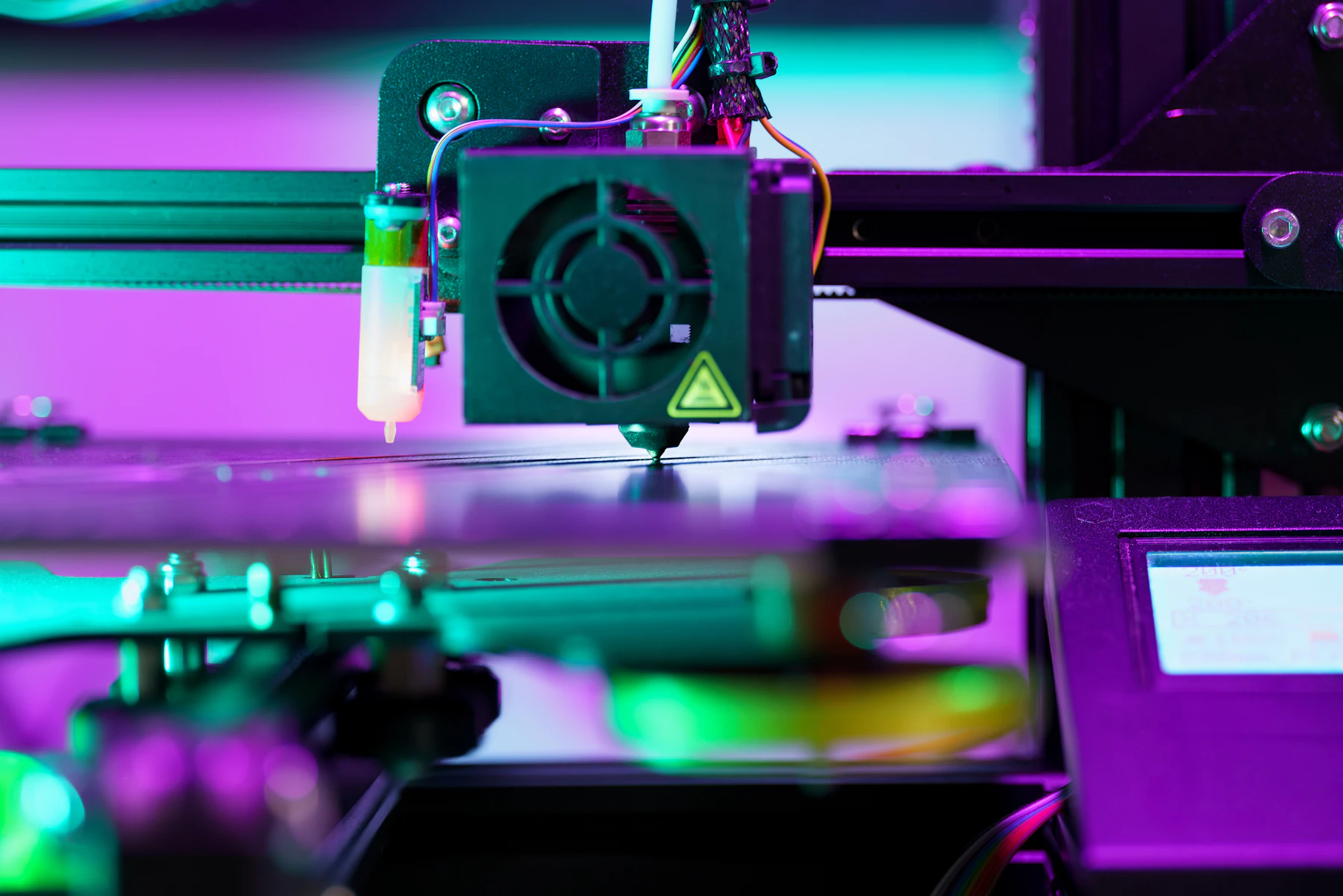 Primer plano de un cabezal de impresora 3D en un entorno de fabricación.