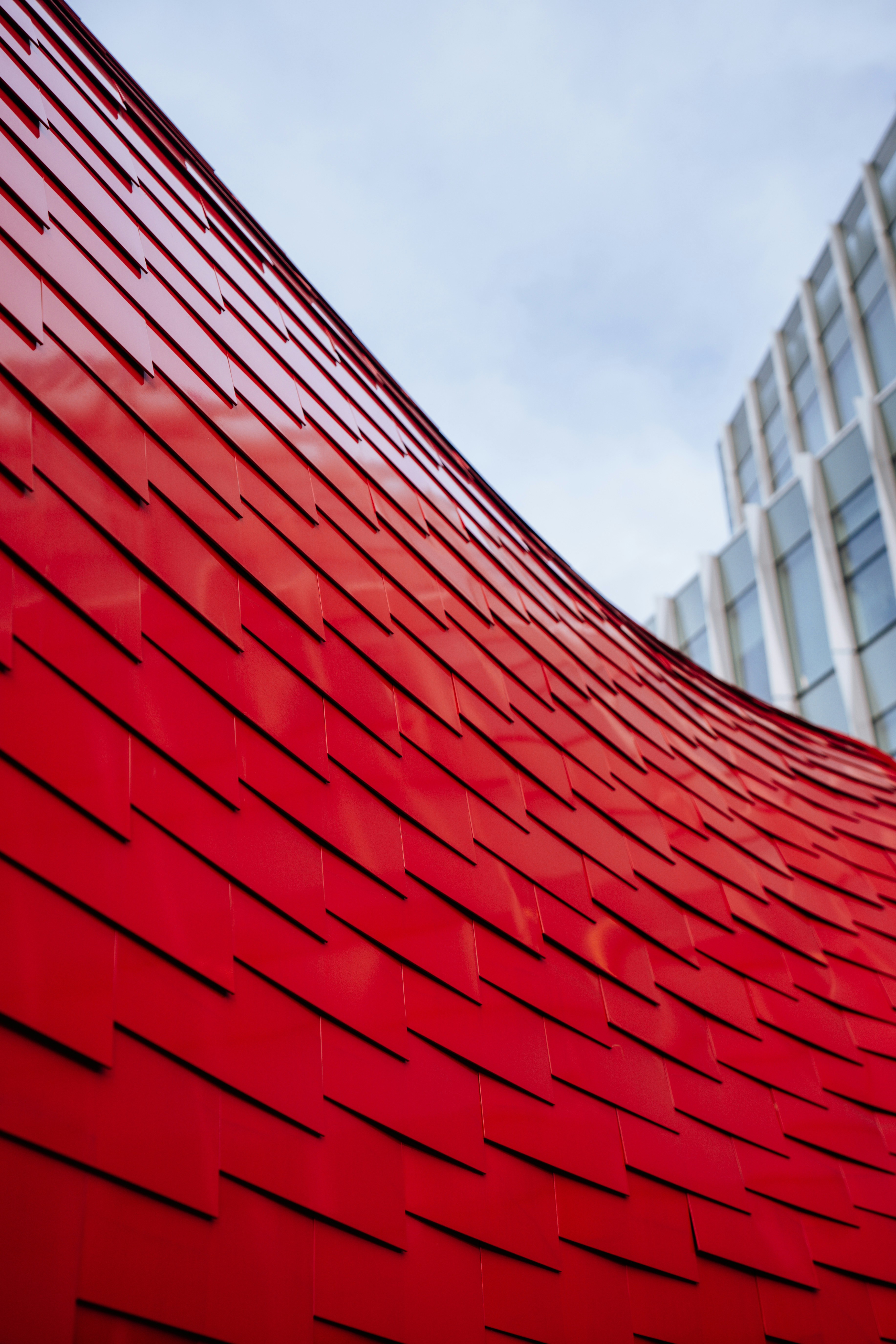 A large red building with a very tall building in the background