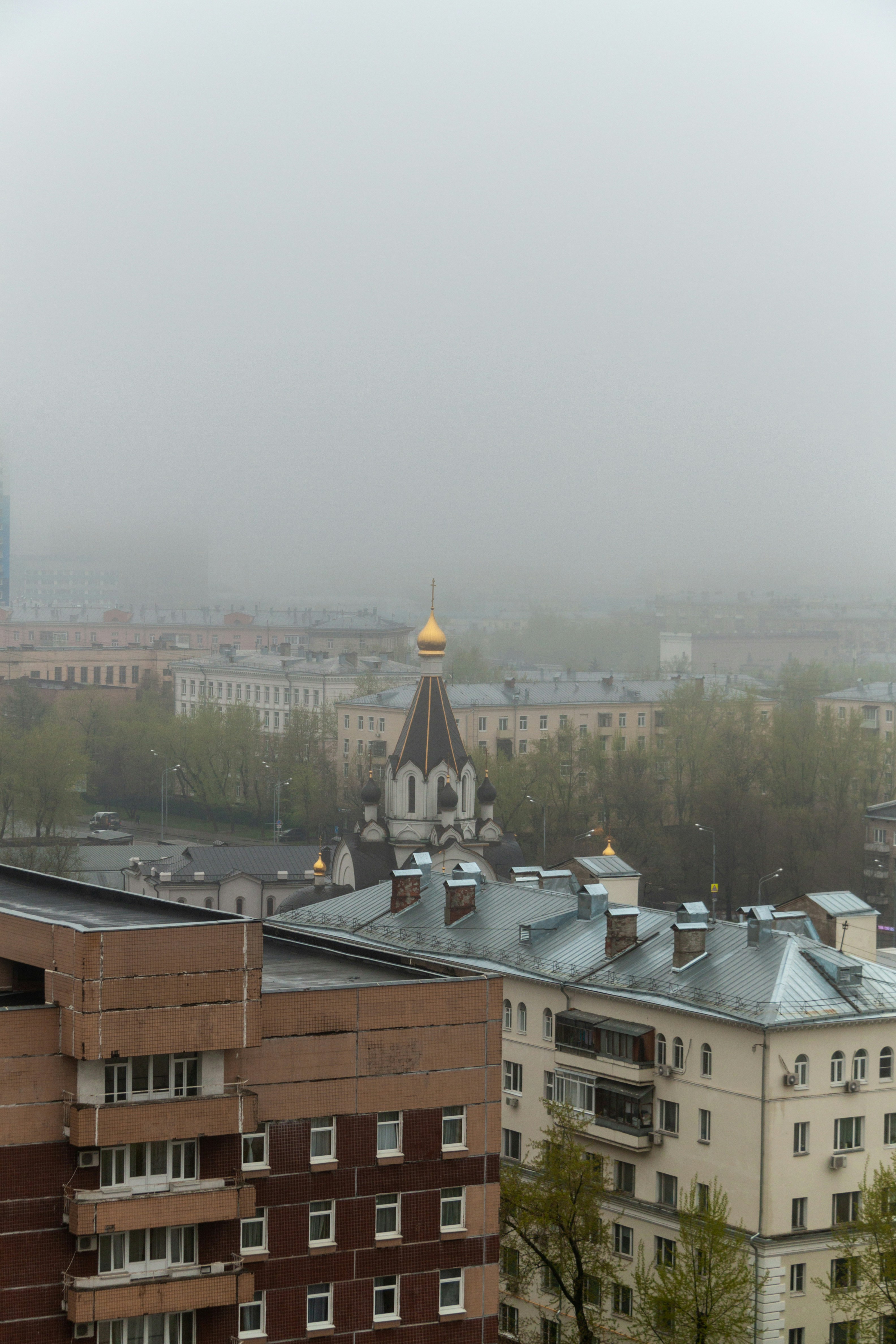 A foggy view of a city with buildings and a clock tower