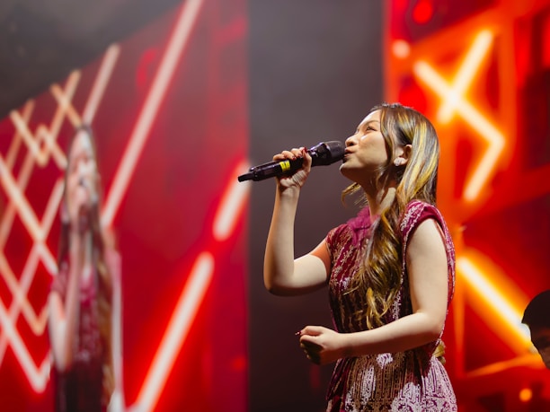 A woman singing into a microphone on stage