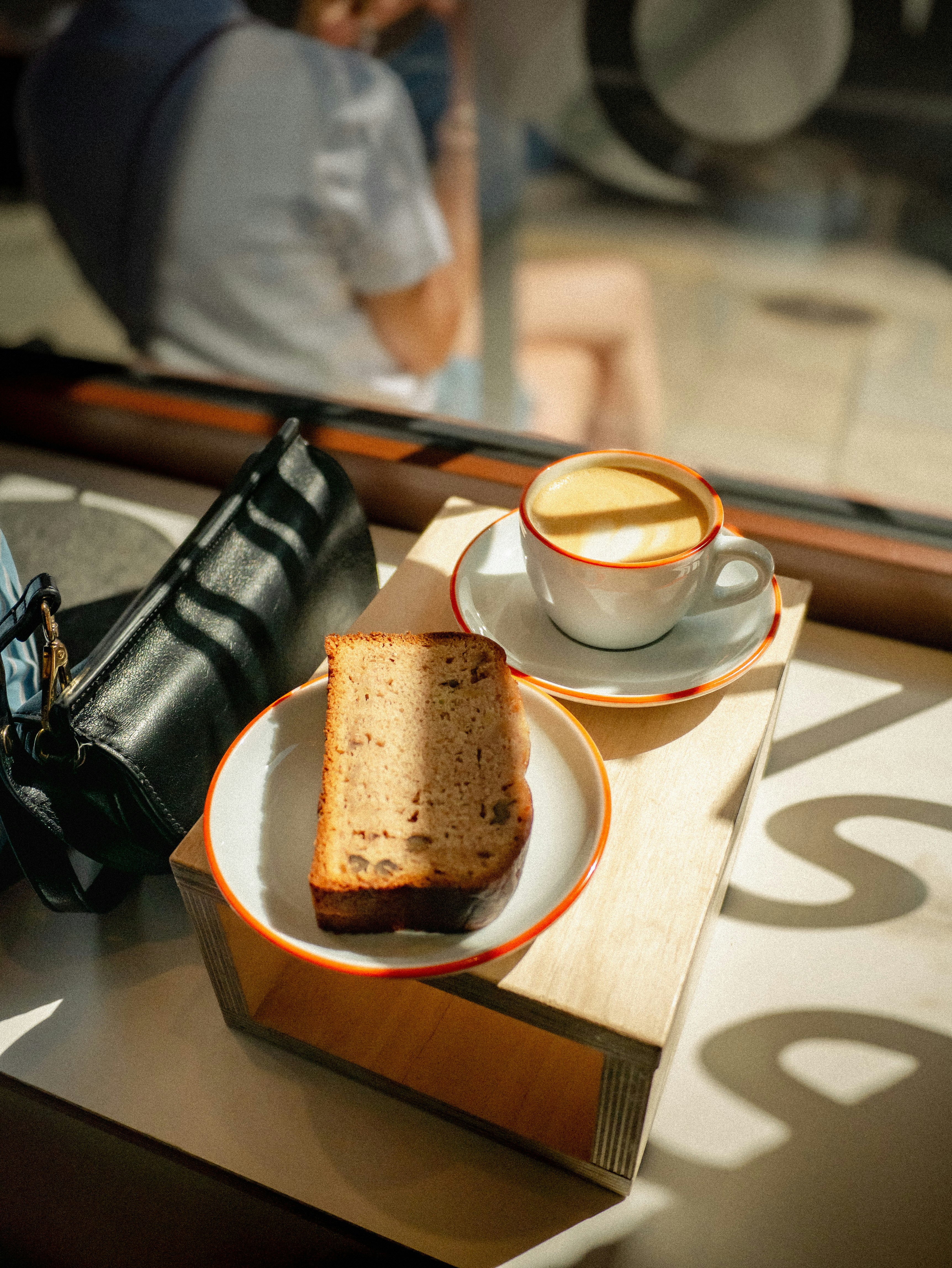 A table with a cup of coffee and a sandwich on it