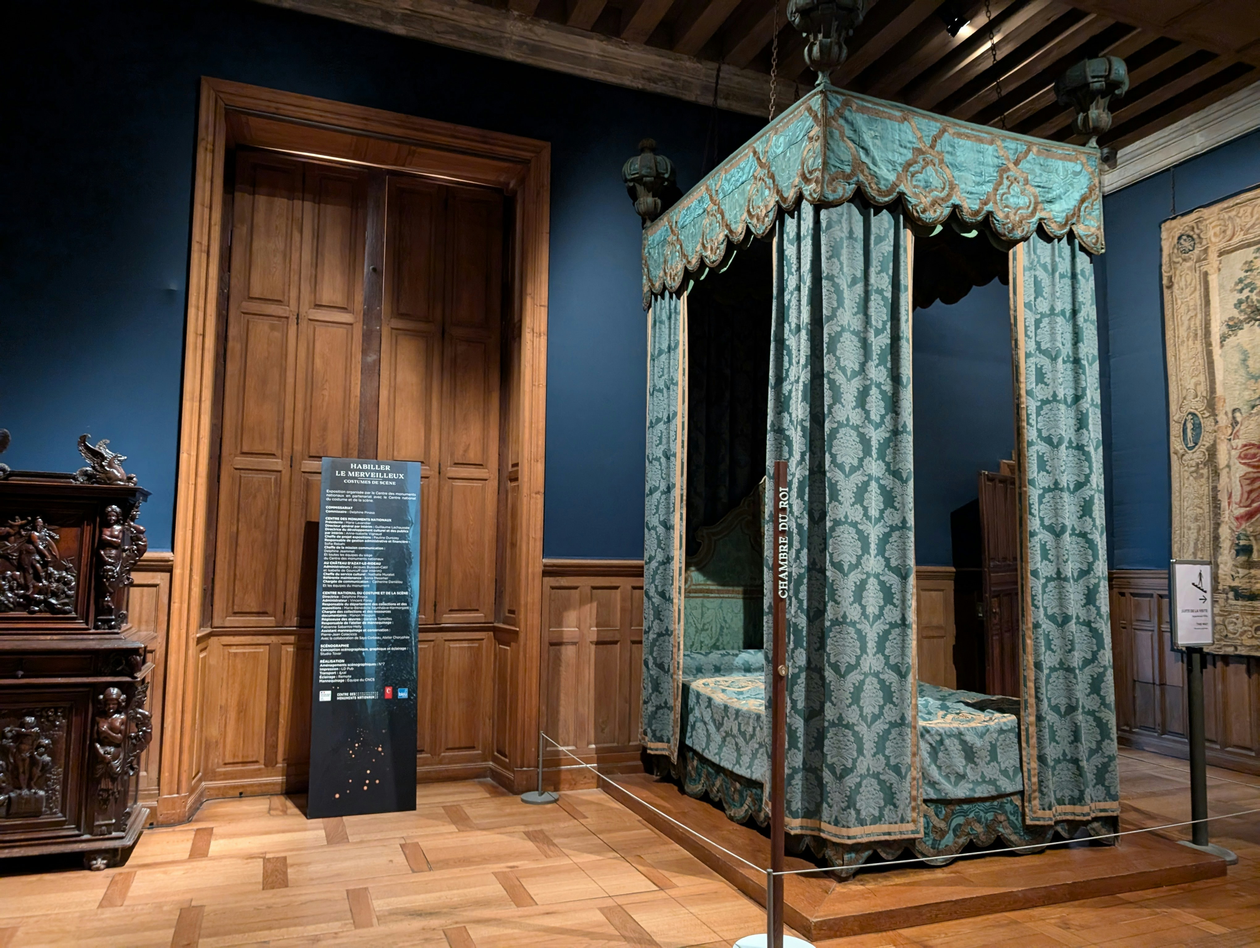 A canopy bed in a room with blue walls