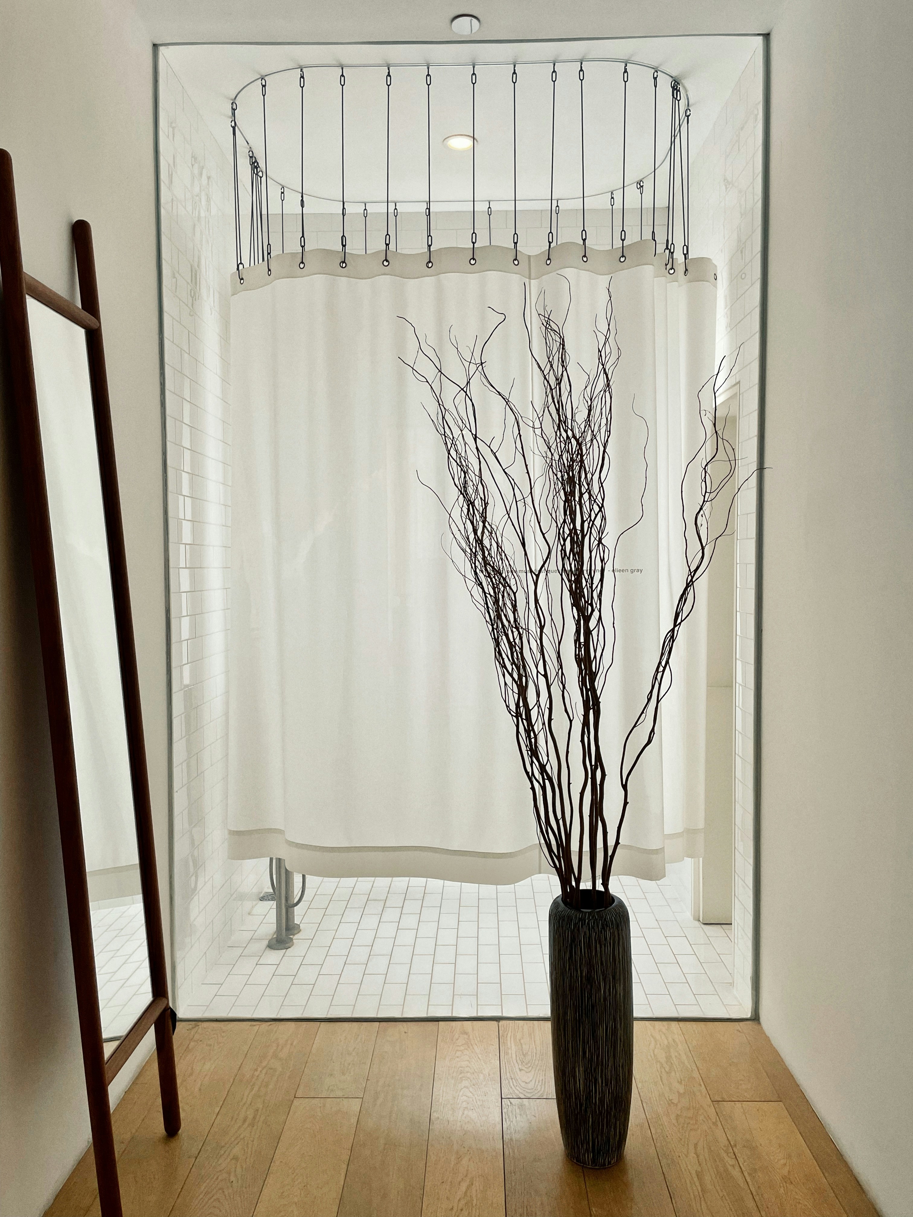 Un vaso con rami seduti su un pavimento di legno