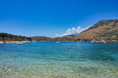The bay at Sarandë, boats on flat blue water with the hills behind