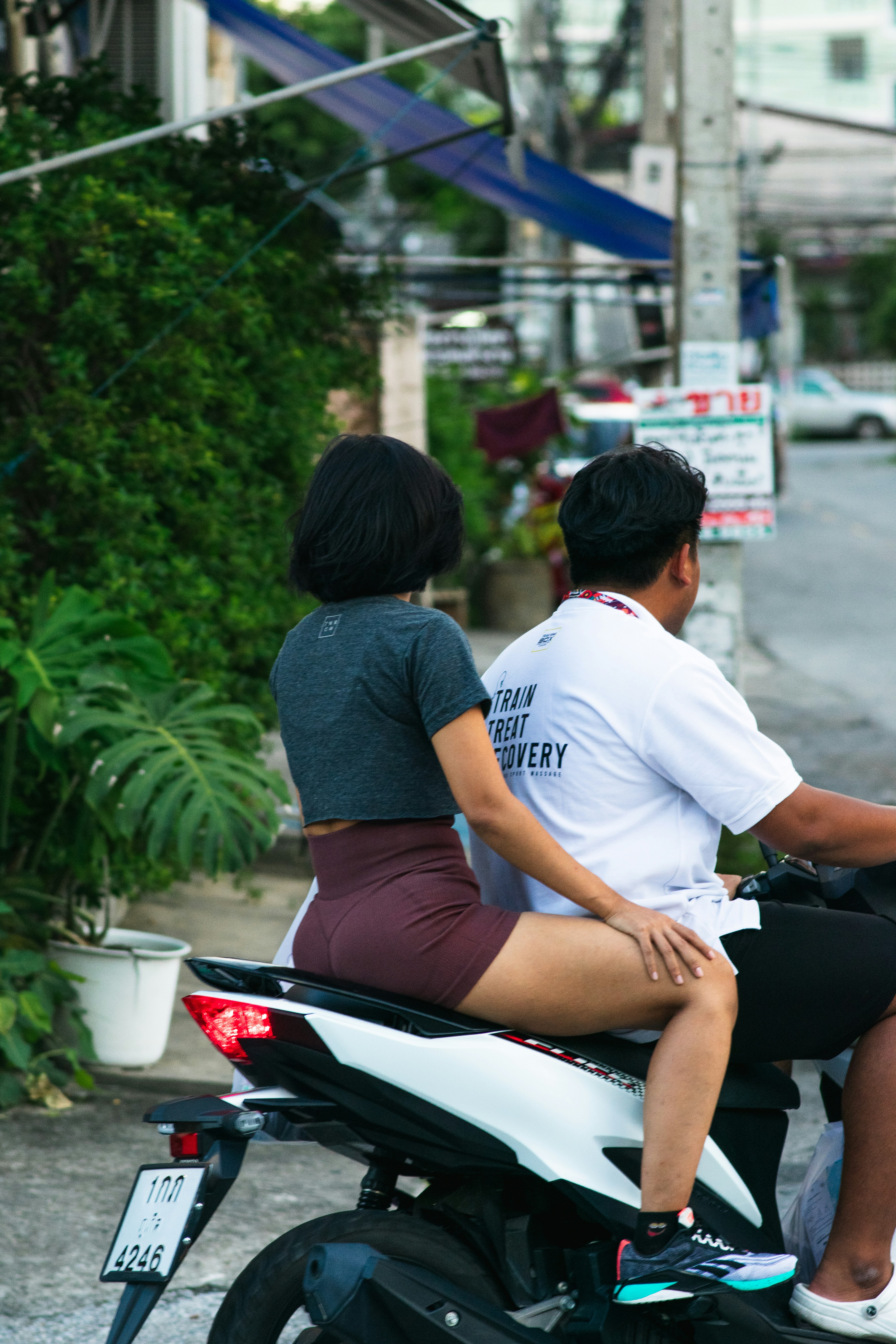 A man and a woman riding on the back of a motorcycle