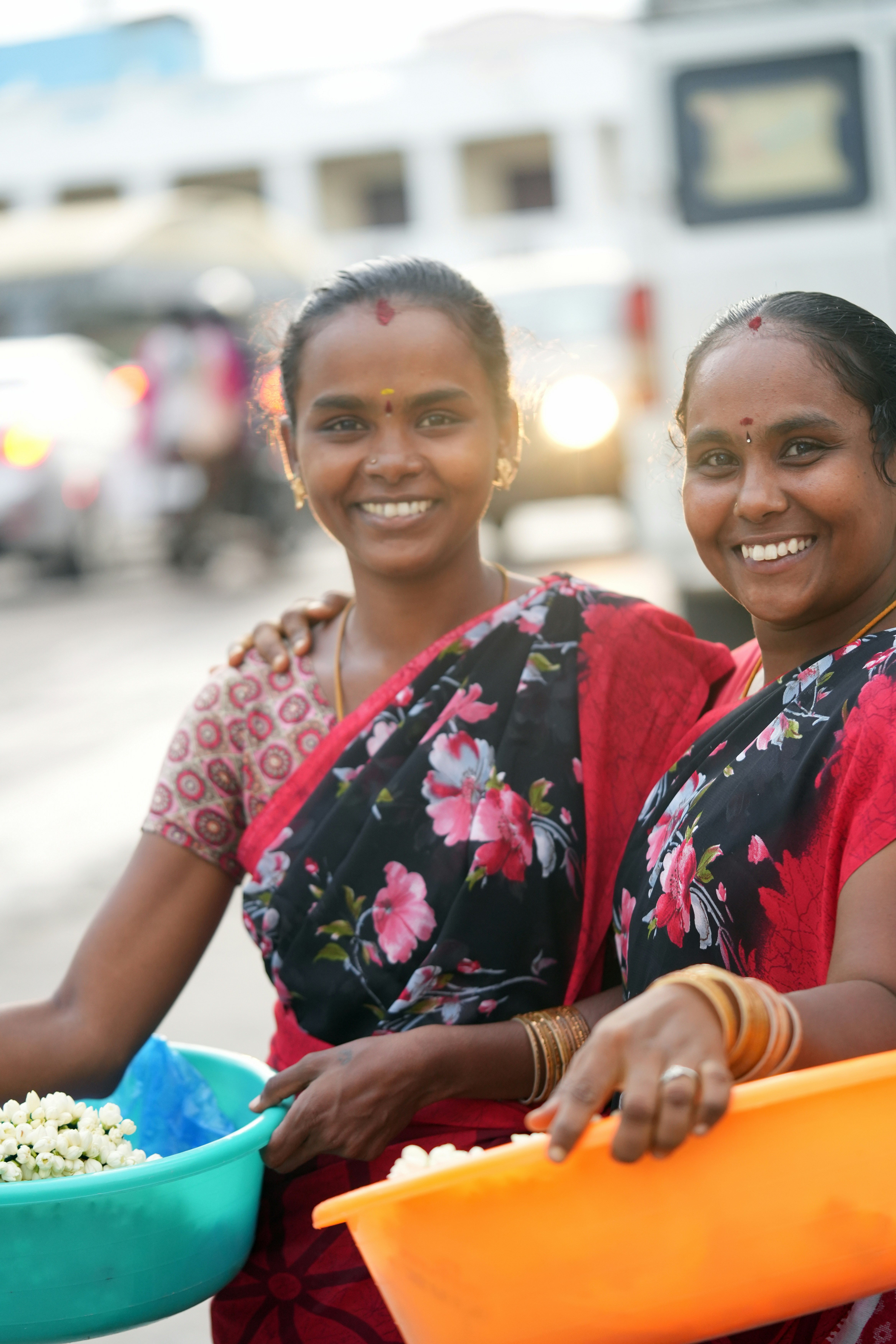 Two women are holding a bowl of popcorn