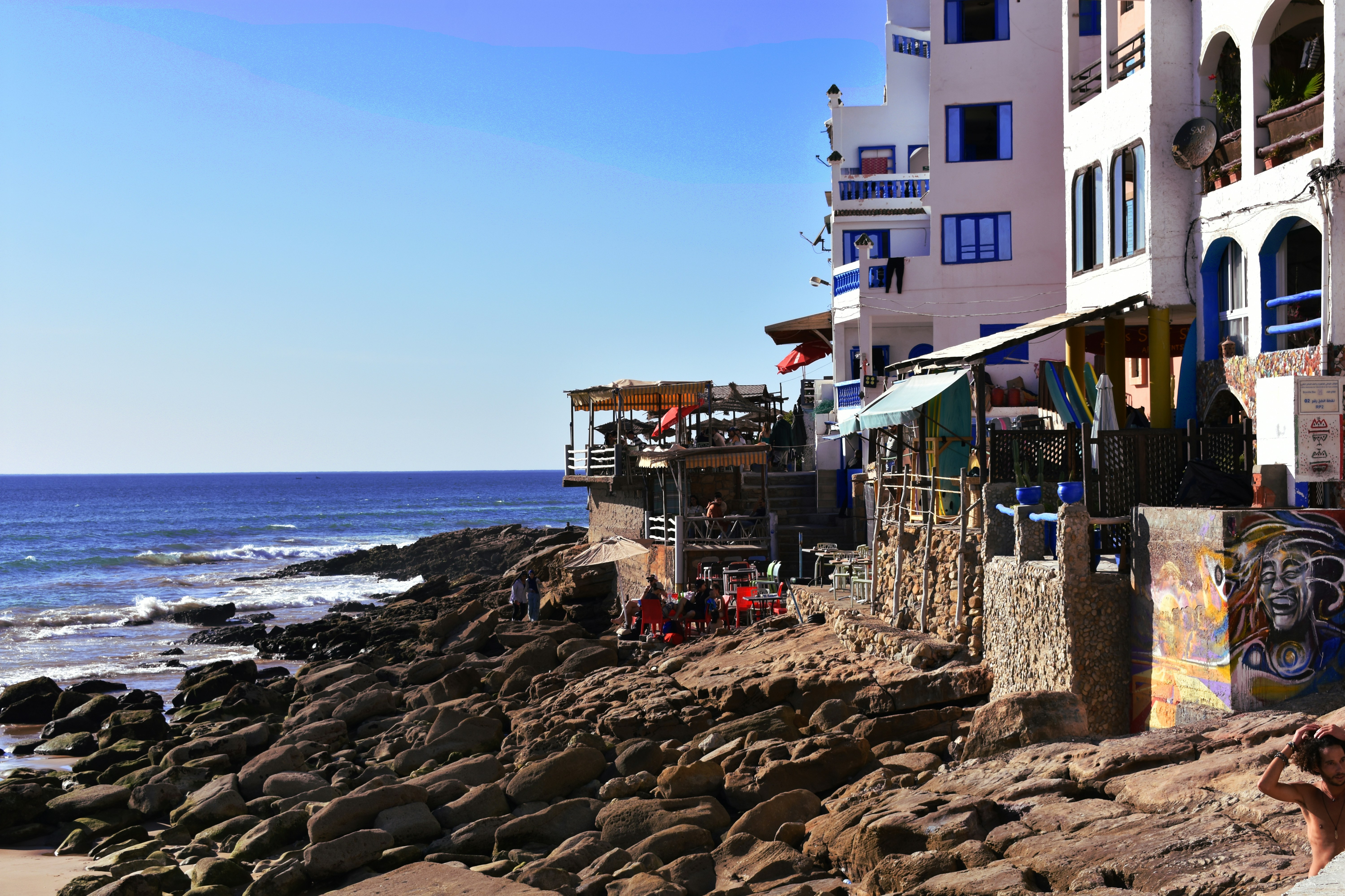 A man sitting on a bench next to the ocean