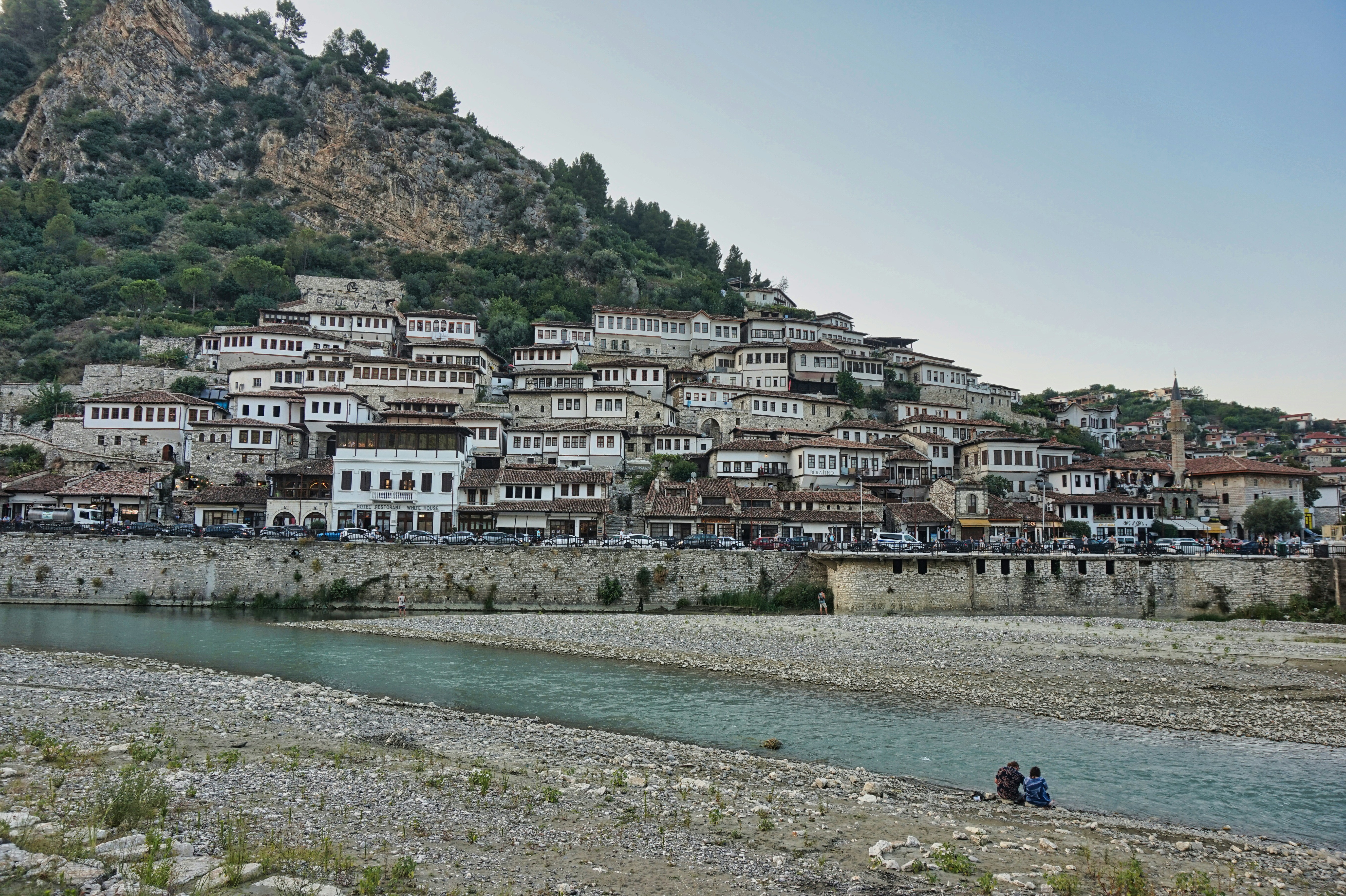 A river running through a small town next to a mountain