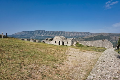 A stone building sitting on top of a lush green hillside