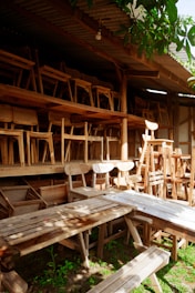 A row of wooden chairs sitting next to a wooden bench