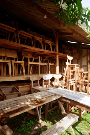 A row of wooden chairs sitting next to a wooden bench