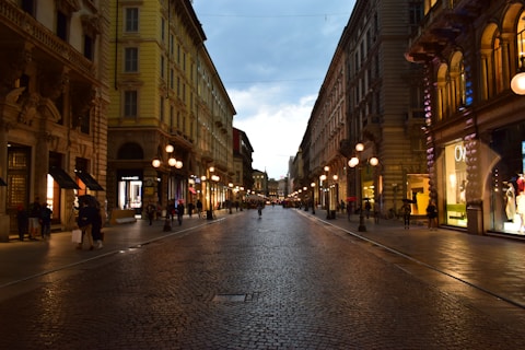 A city street at night with people walking on it