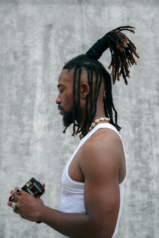 A man with dreadlocks holding a camera
