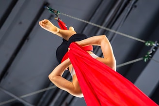 Women suspended with red silk fabric