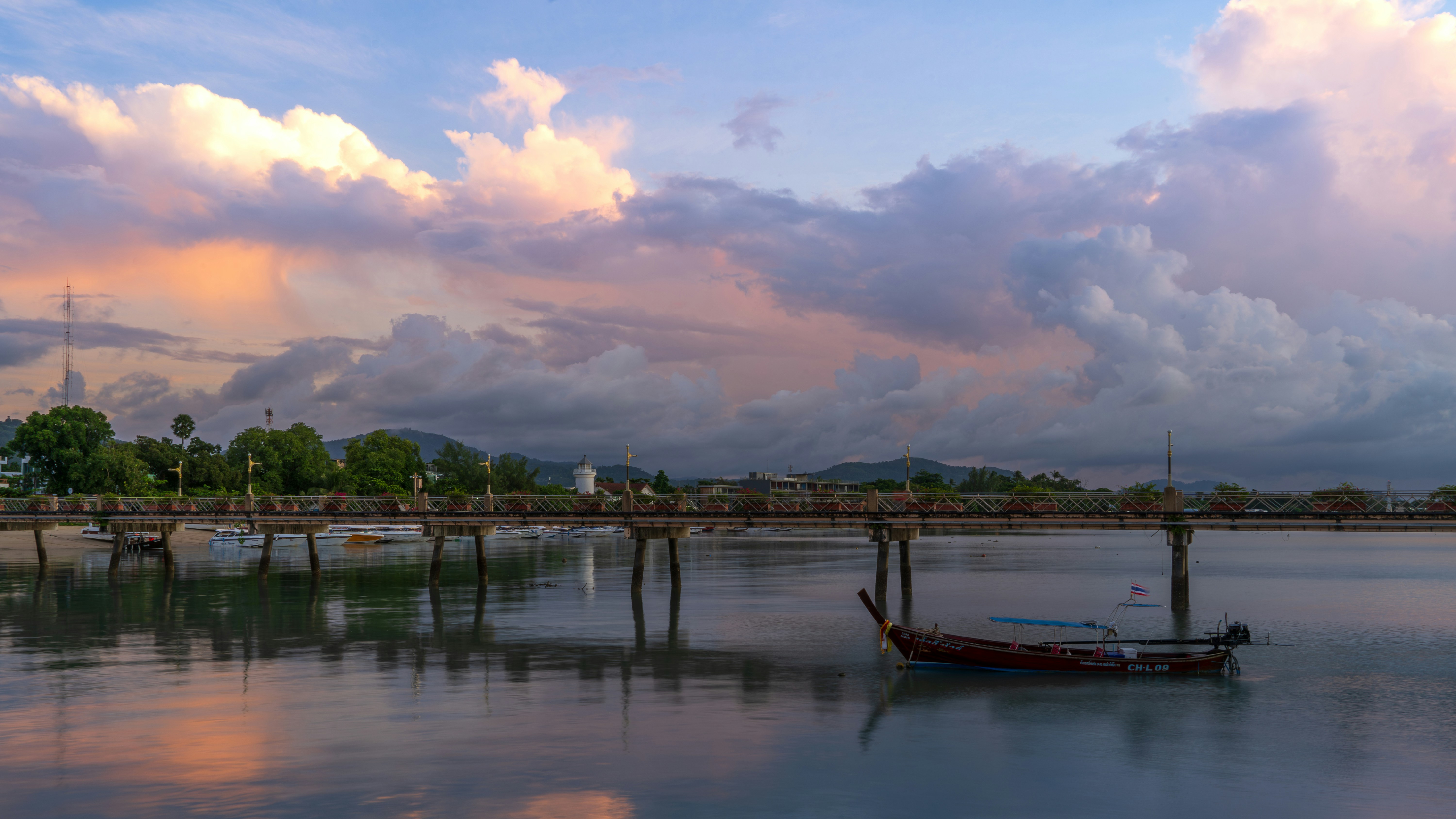 A boat floating on top of a lake under a cloudy sky