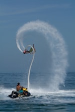 A man riding a jet ski while being pulled by a boat