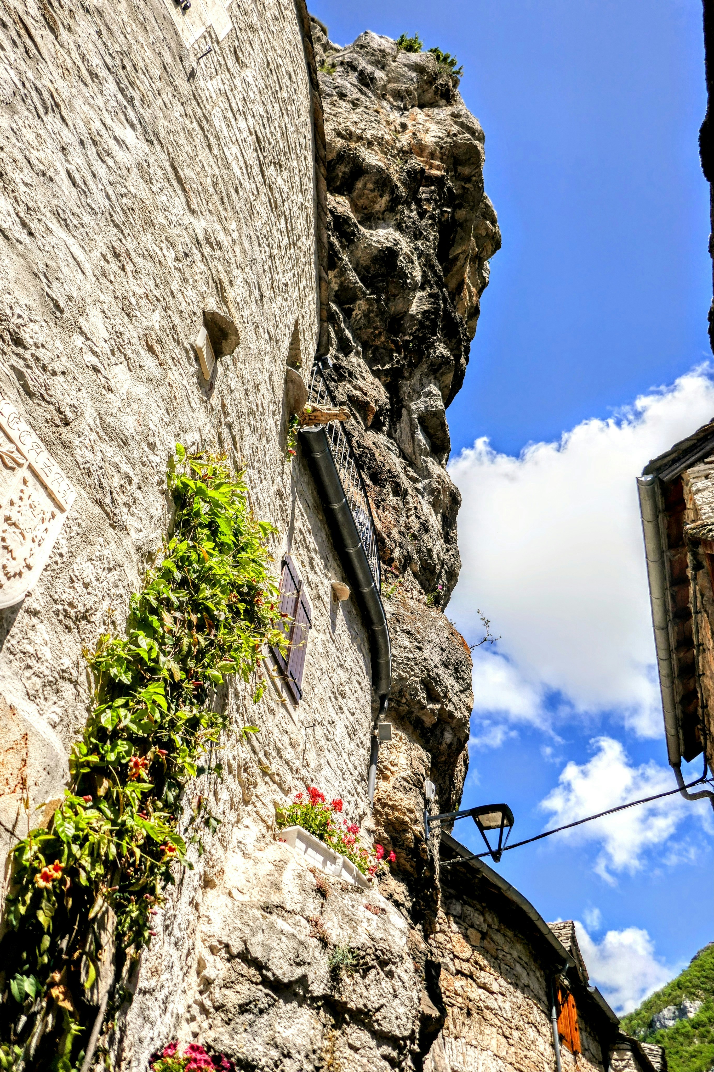 A stone building with flowers growing out of it