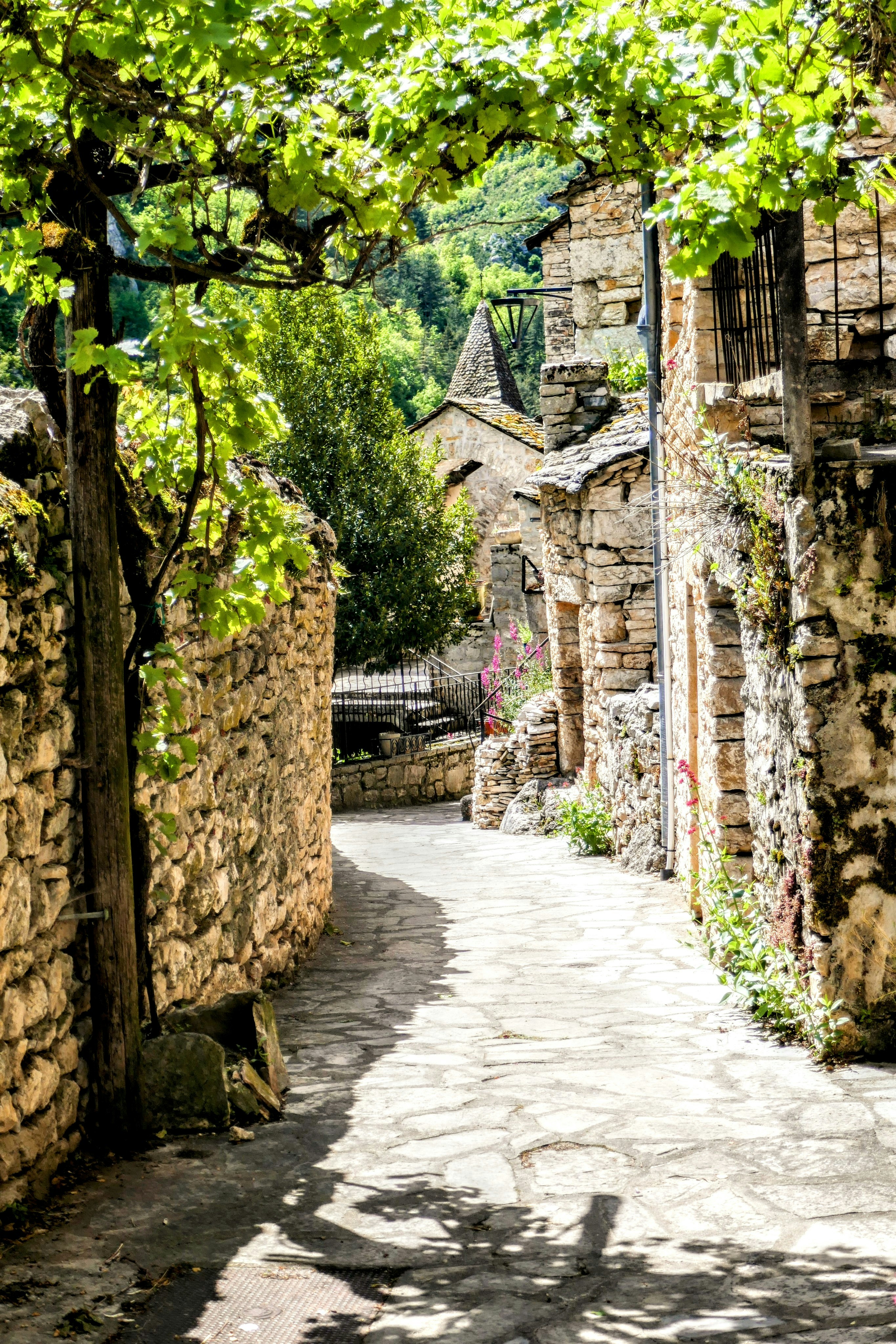 A cobblestone street with a stone building in the background
