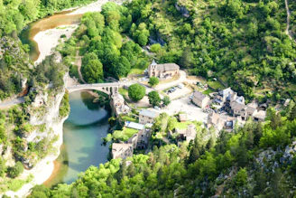 An aerial view of a river running through a lush green forest