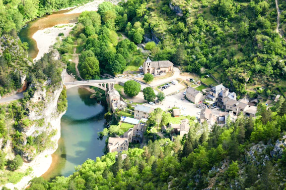 An aerial view of a river running through a lush green forest