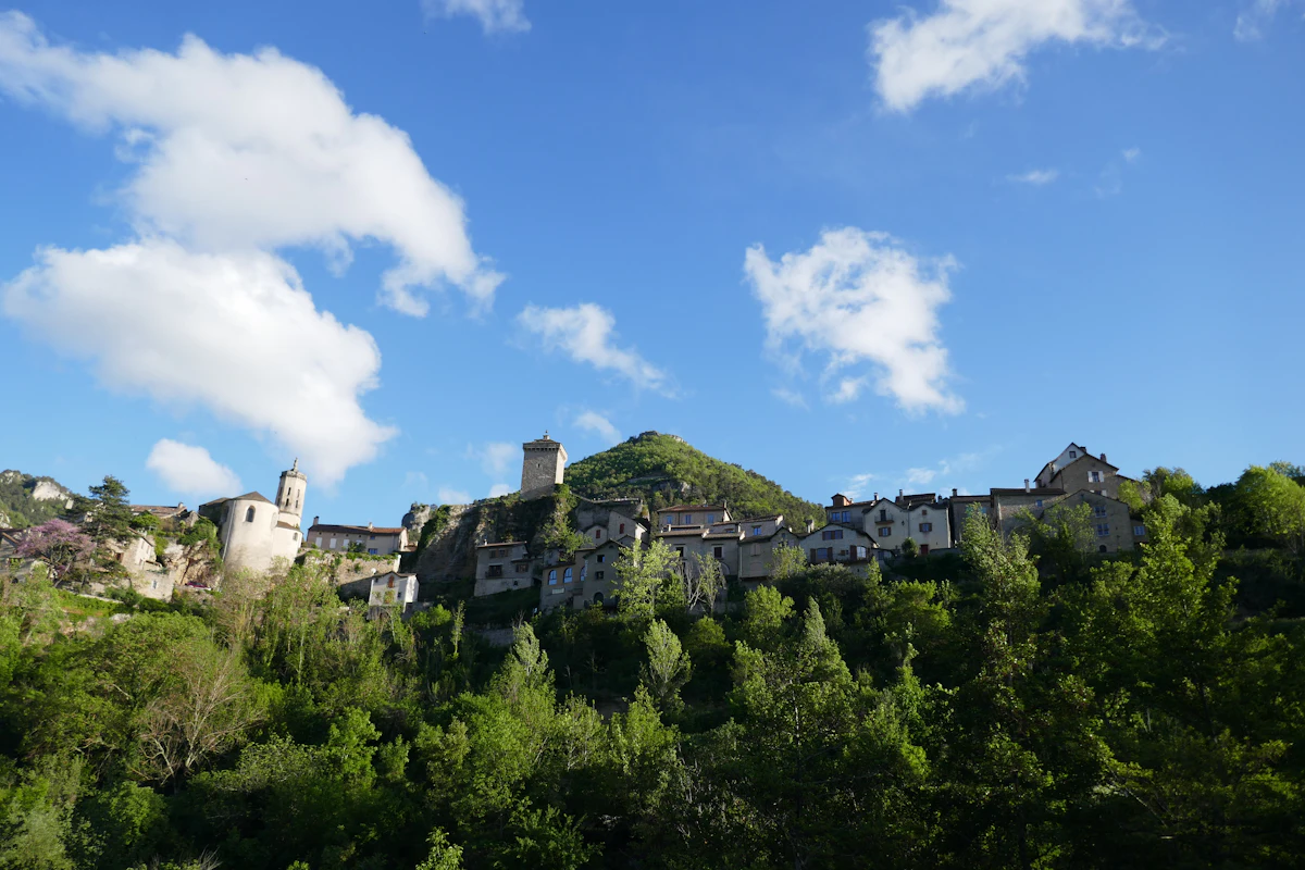 A stone village with a tower among the trees in the Gorges du Tarn
