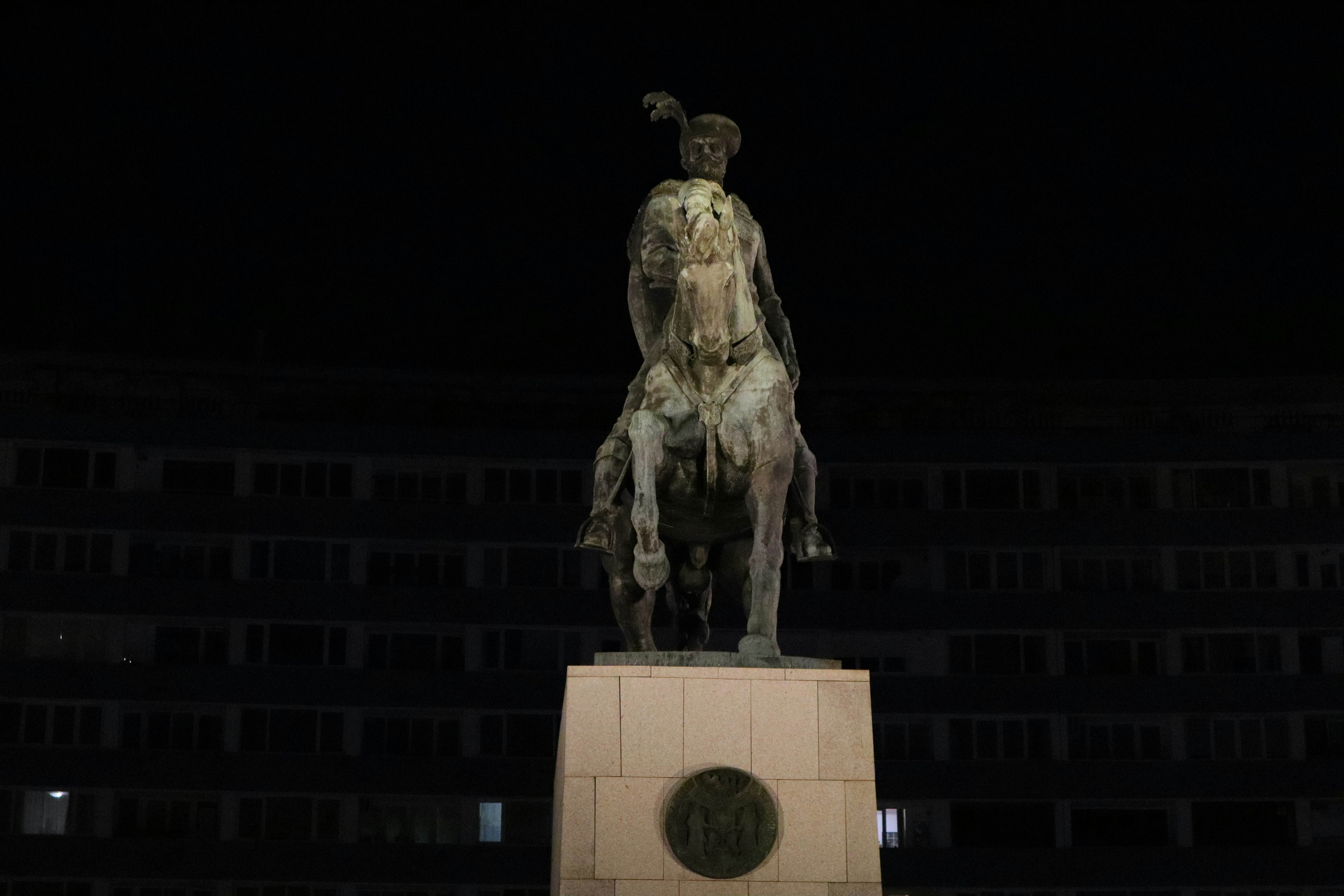 A statue of a man riding a horse at night