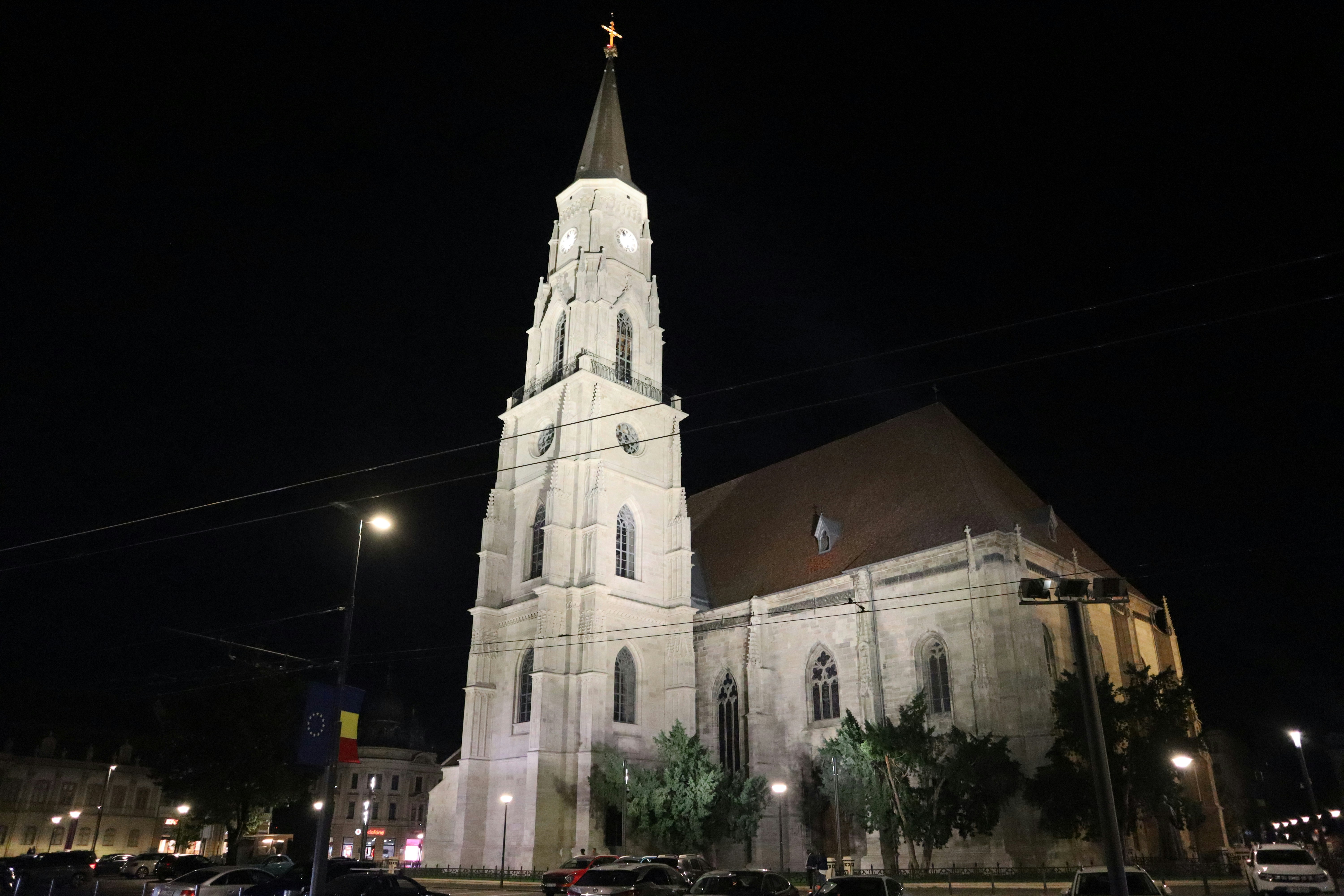 A large white church with a steeple at night