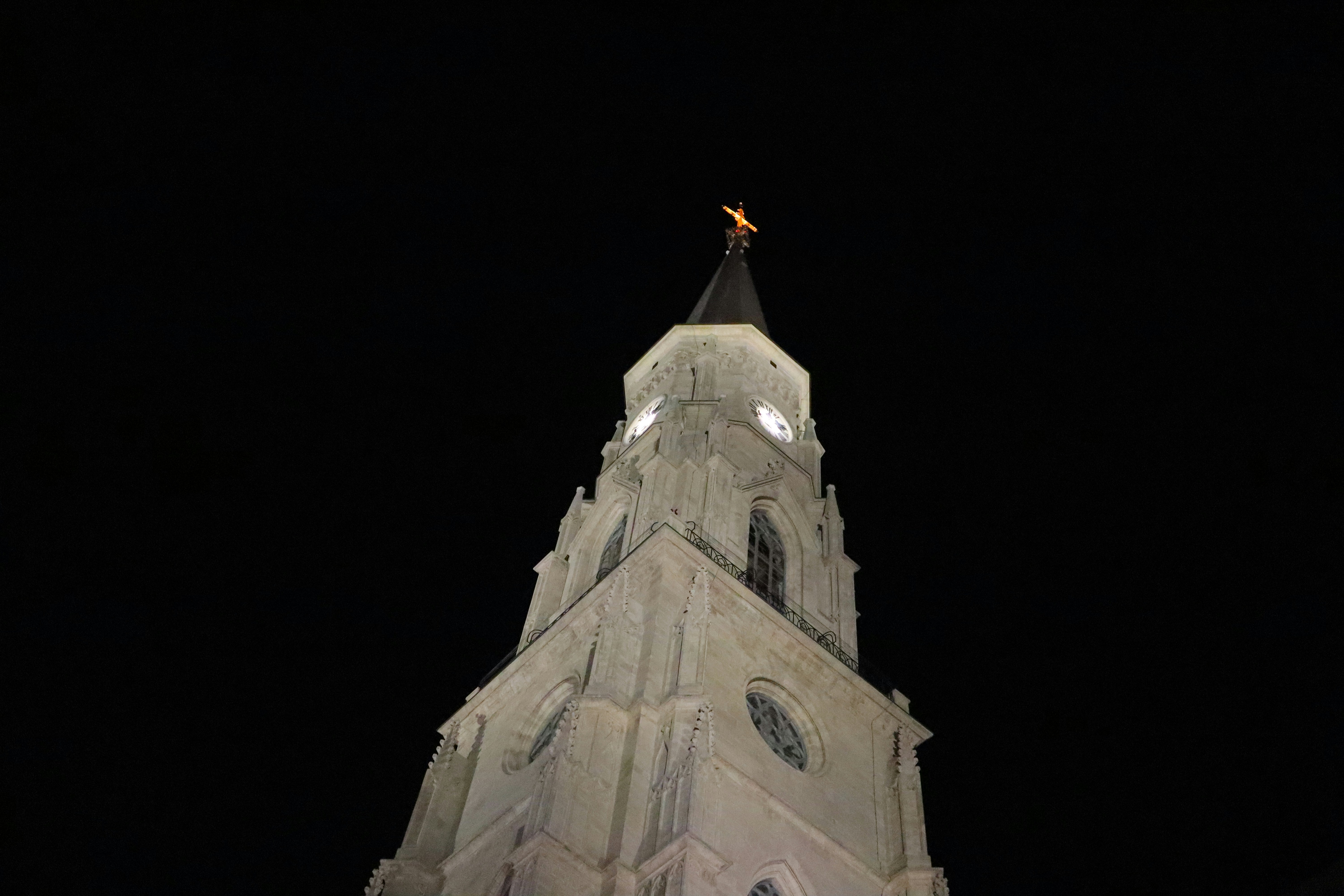 A tall clock tower lit up at night