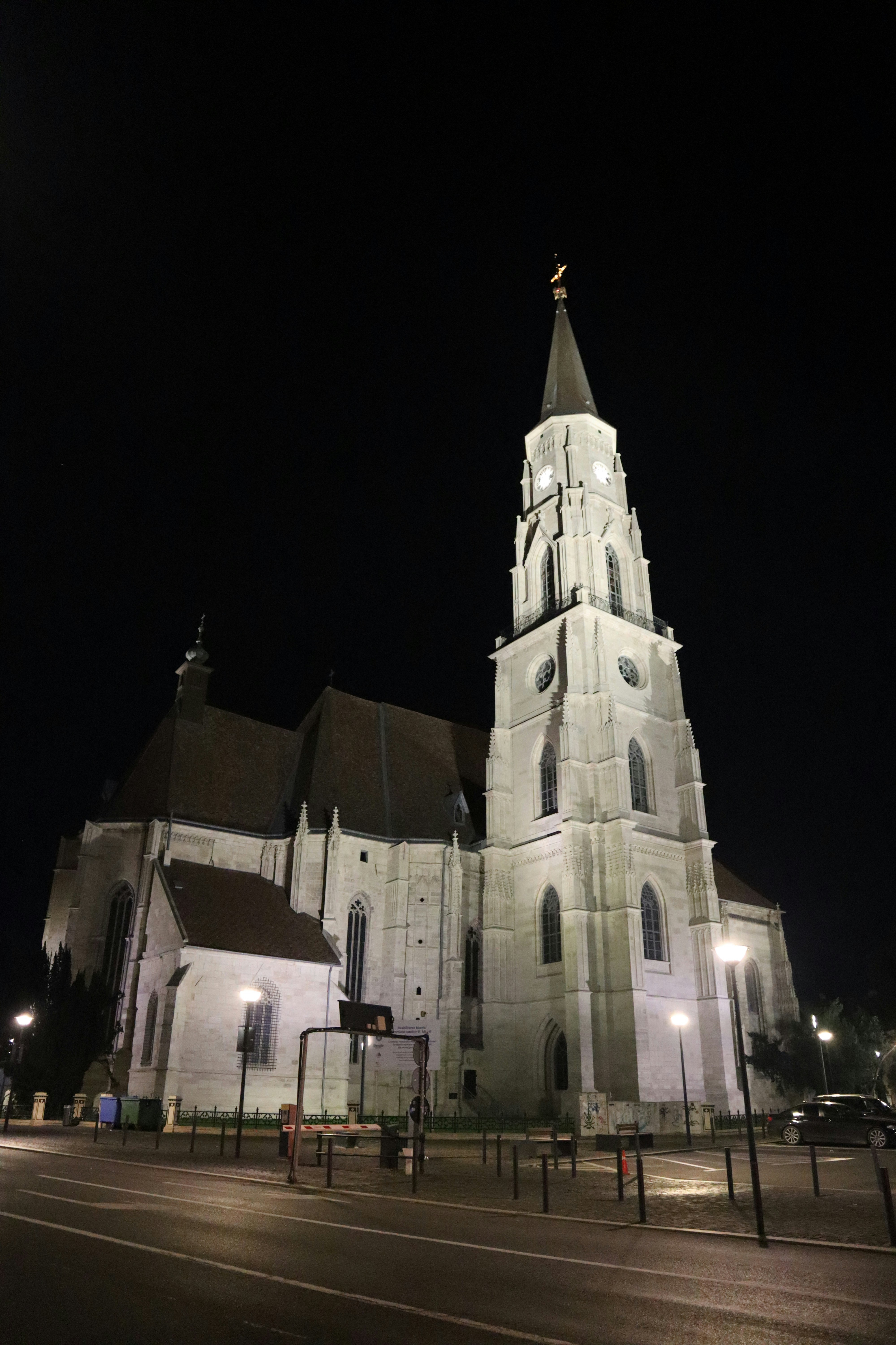 A church lit up at night with a clock tower
