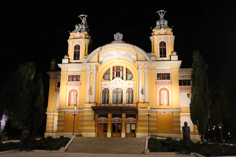 Yellow twin-towered building lit at night, Cluj-Napoca, Romania