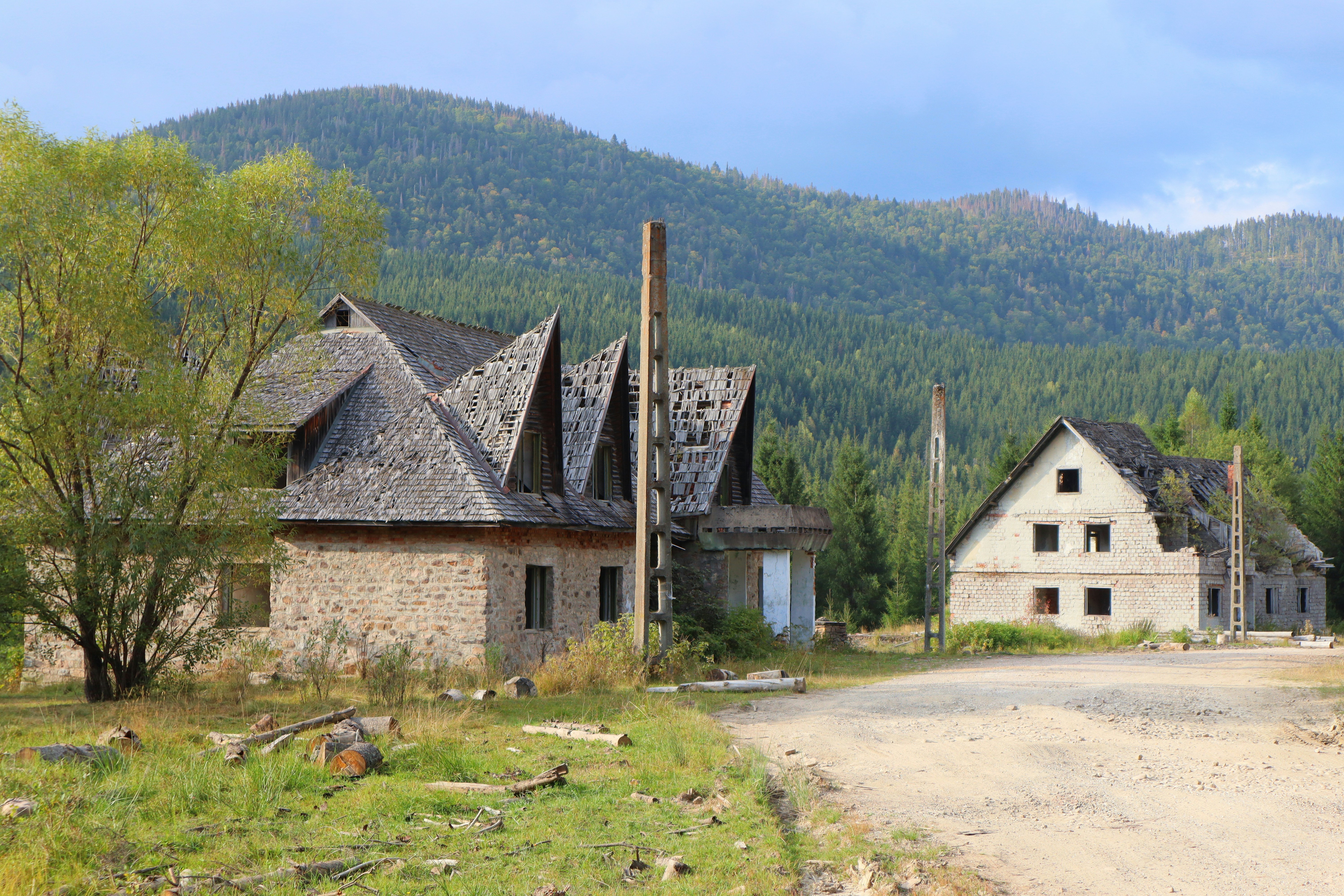 A dirt road in front of a stone building