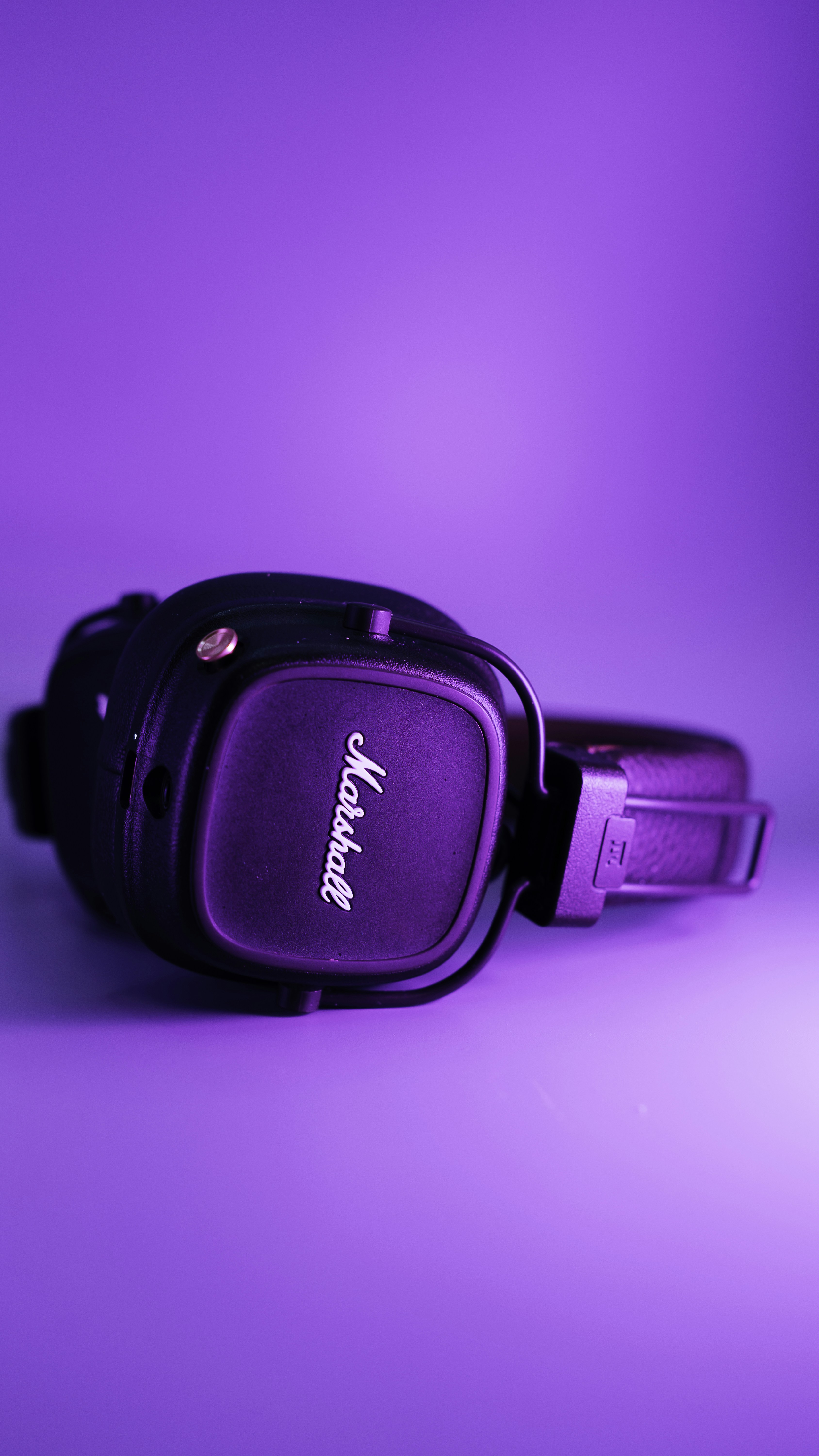 A pair of headphones sitting on top of a purple surface
