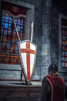 A knight standing in front of a shield and sword