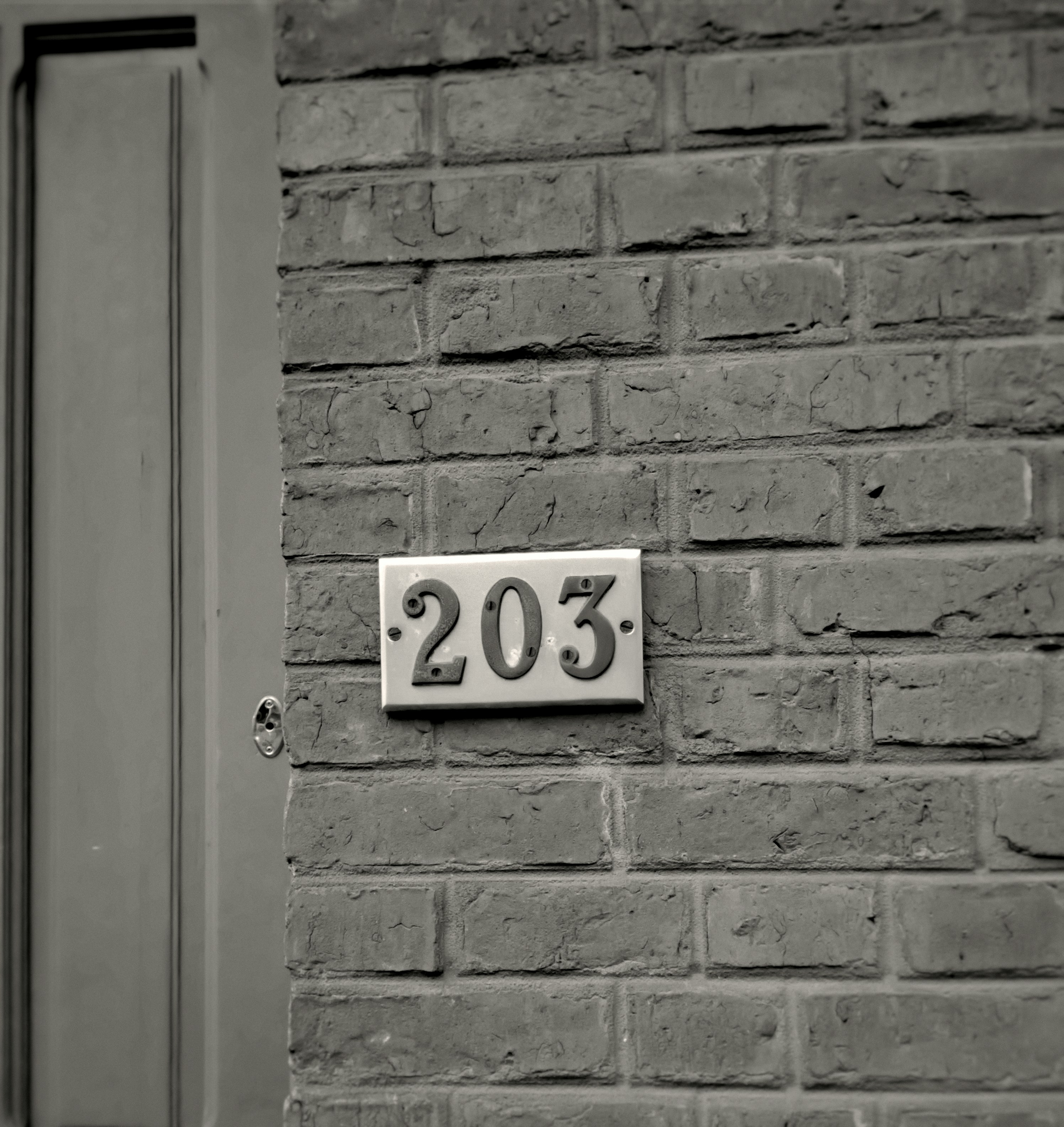 A brick building with a door and a sign on it