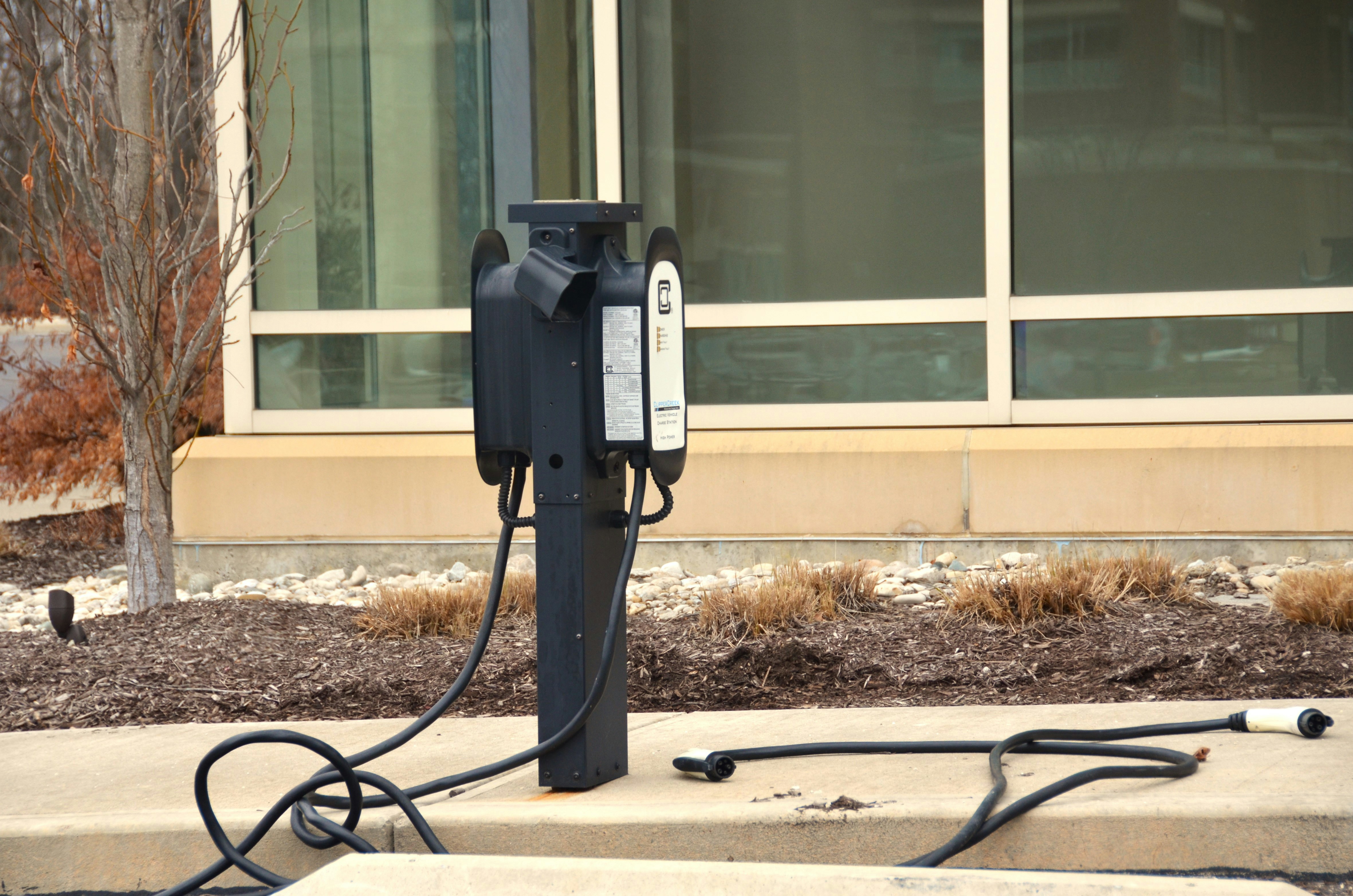 Electric SUV plugged into a home charger in a suburban driveway