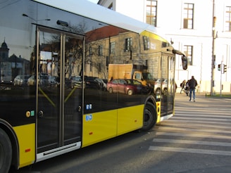 A black and yellow bus driving down a street