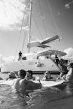 A group of people in the water with a catamaran