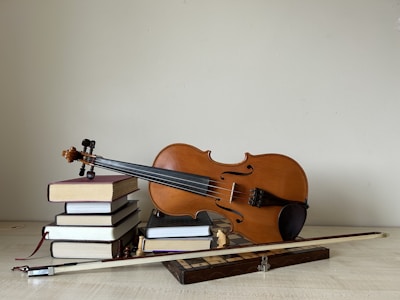 A violin sitting on top of a pile of books