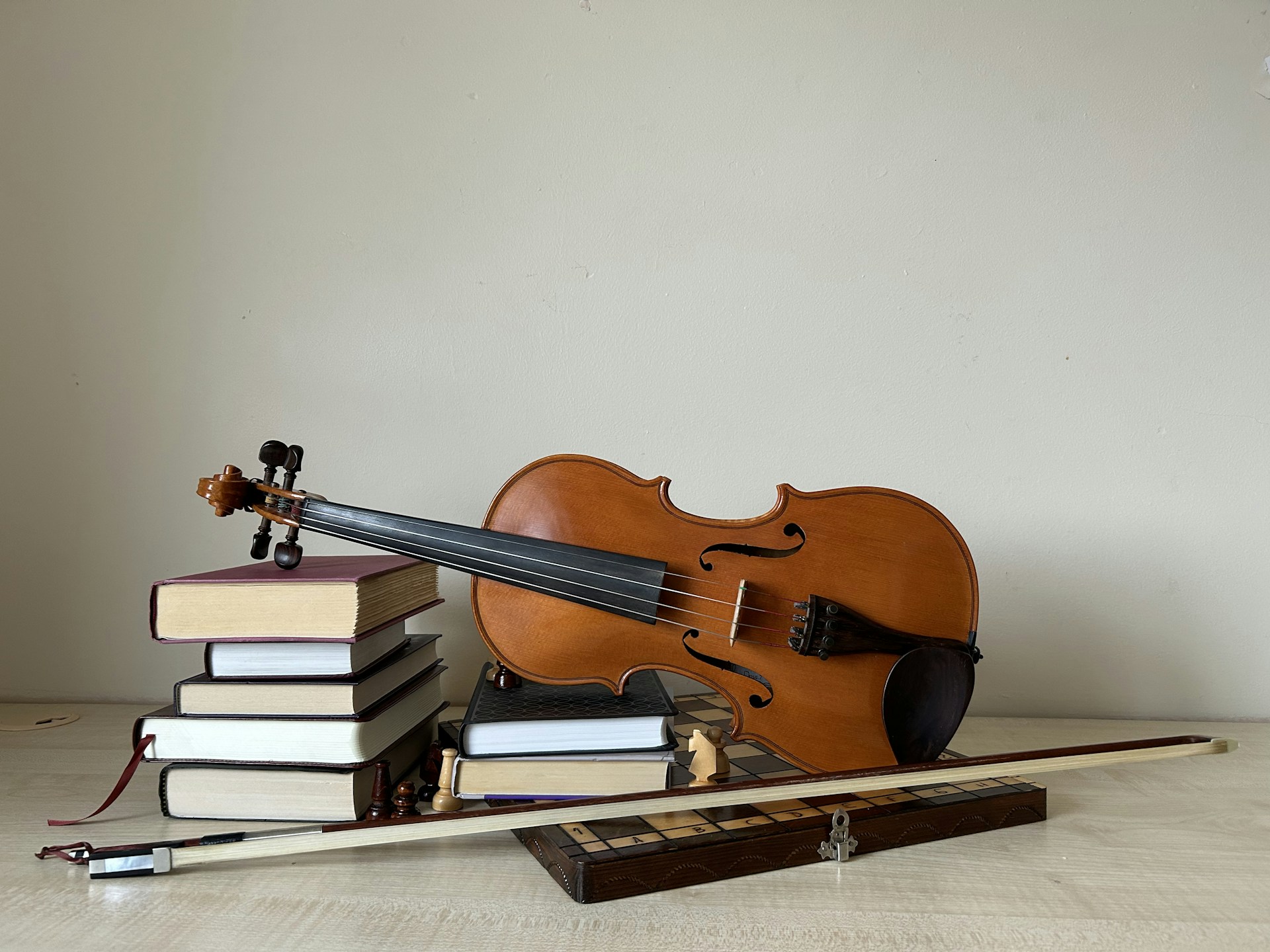 A violin sitting on top of a pile of books