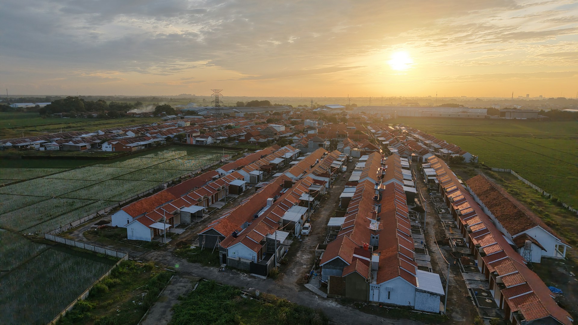 An aerial view of a city with a sunset in the background