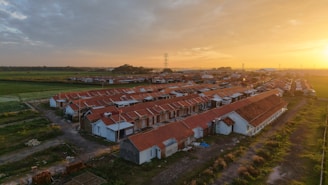 A bird's eye view of a farm with a sunset in the background