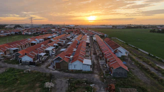 An aerial view of a village with a sunset in the background