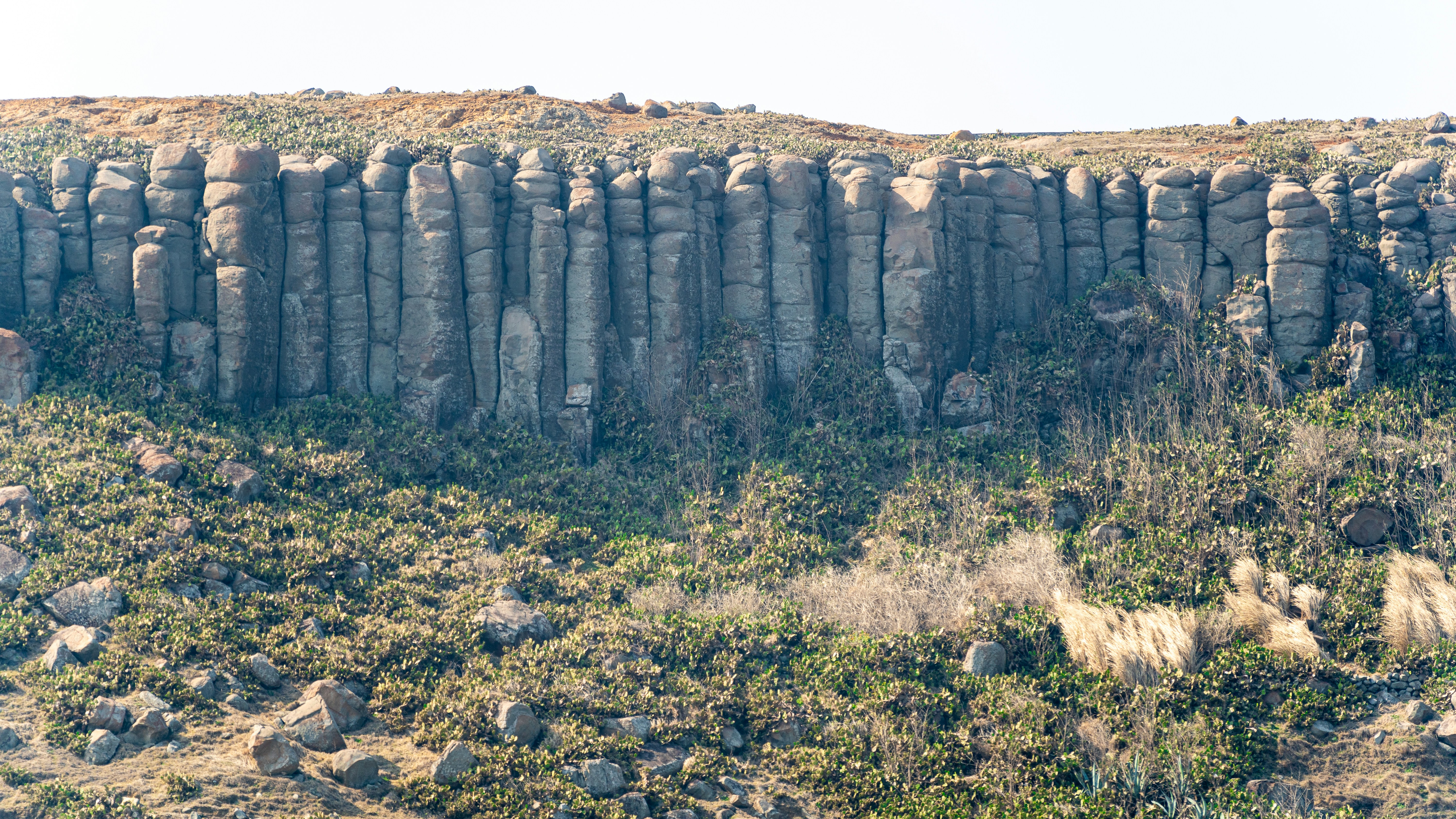 A large rock formation in the middle of a field