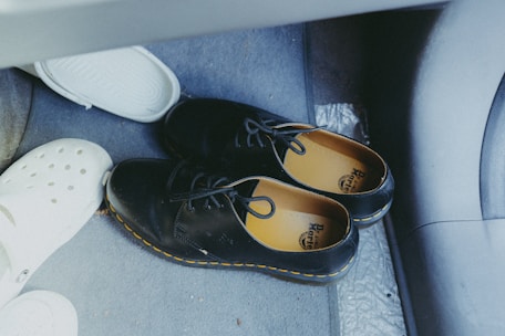 A pair of shoes sitting on the floor of a car