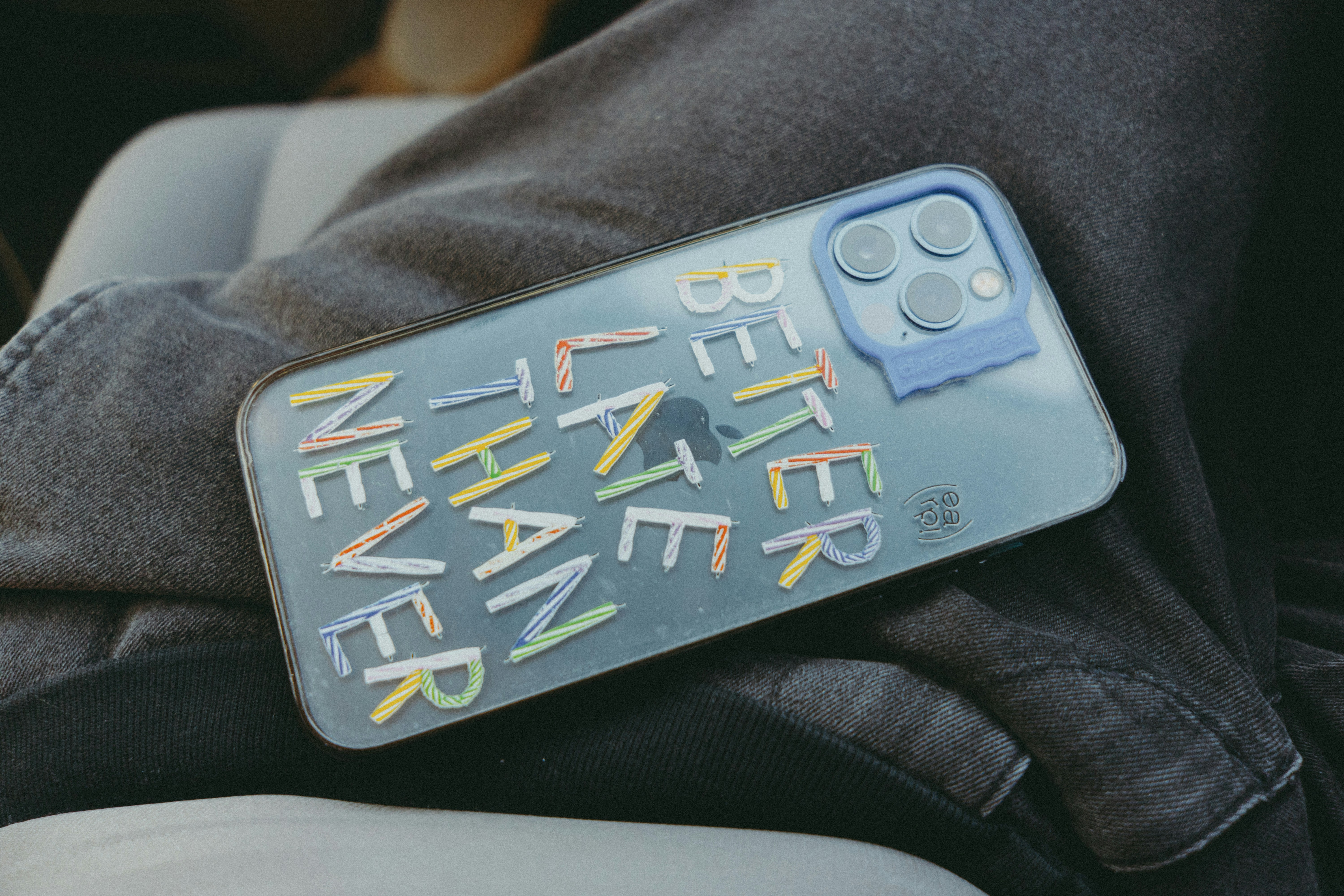 A person holding a cell phone in their lap