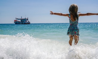 A little girl is jumping into the ocean