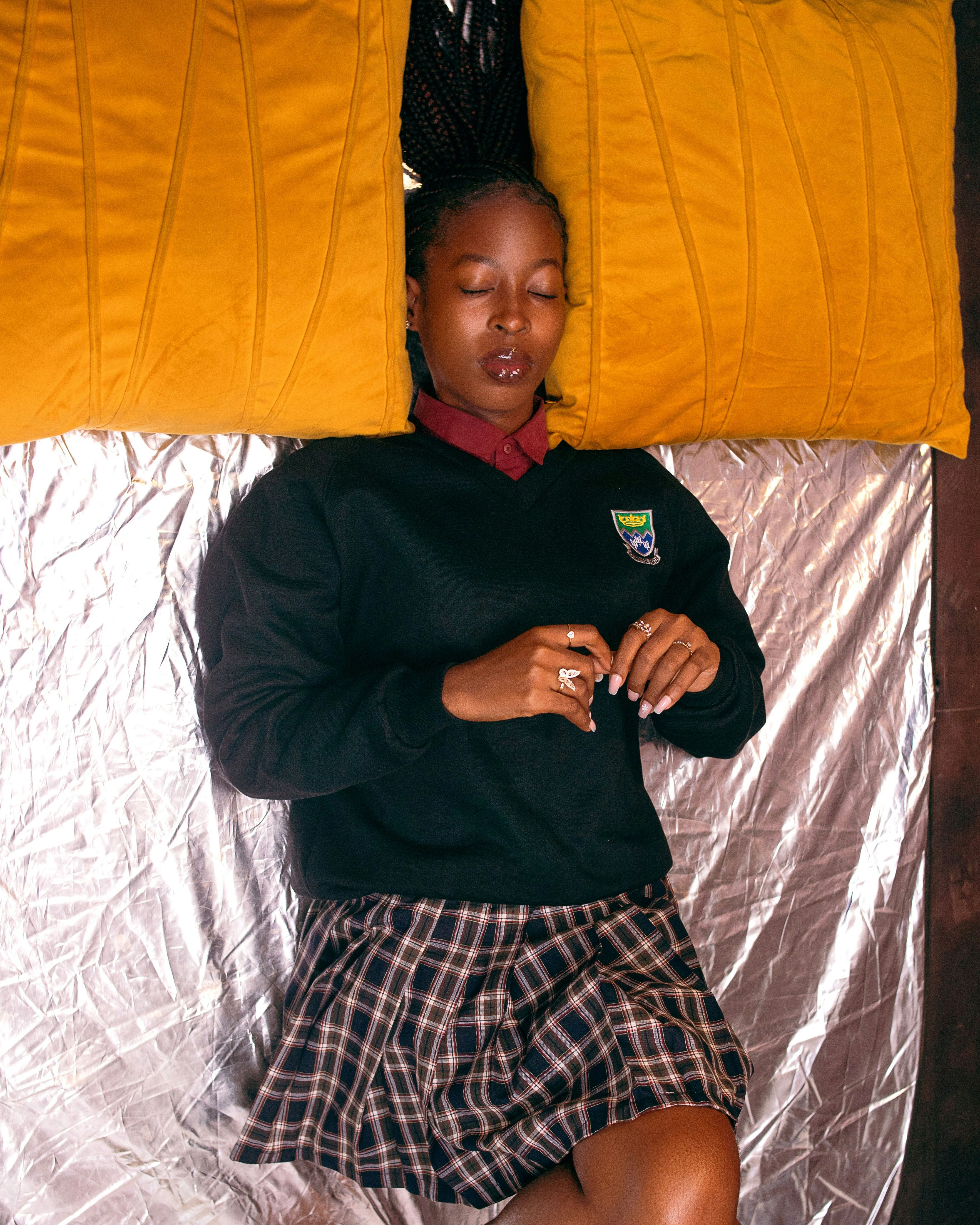 A woman laying on a bed with a pillow on top of her
